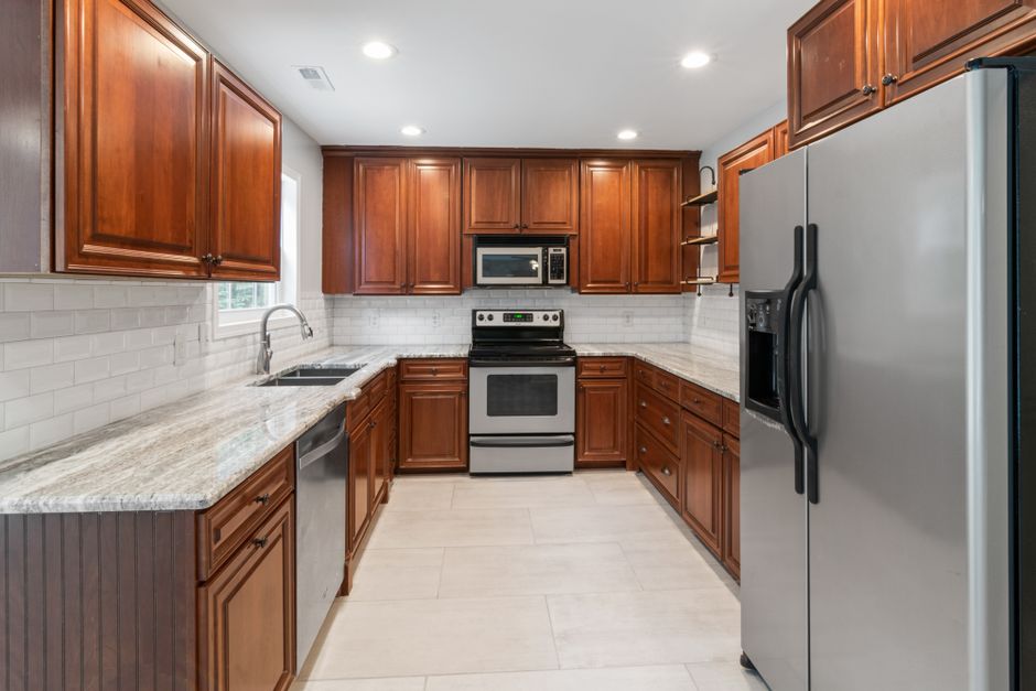Spacious kitchen featuring stainless steel appliances, wooden cabinets, and granite countertops
